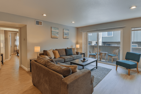 A living room with a grey couch and a blue chair.