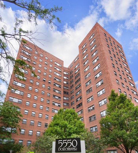 A tall red brick building with the number 5550 on a sign in front.