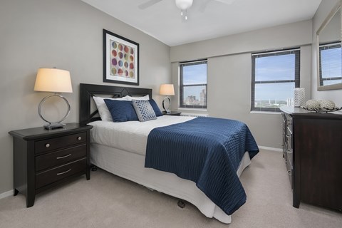 A bedroom with a bed, nightstand, and two lamps.