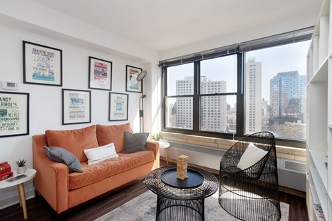 A living room with a couch, chair, and pictures on the wall.