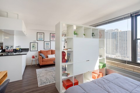 A modern bedroom with a large bed and a city view.