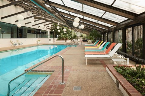 A pool with a metal railing and a glass ceiling.