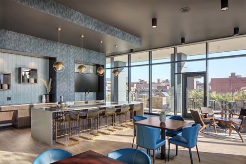 A modern kitchen and dining area with blue chairs and a wooden table.