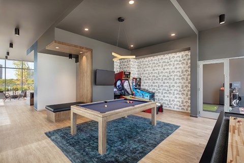 A pool table in a room with a TV and a patterned wallpaper.