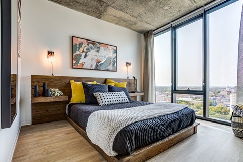 A bedroom with a large bed and a view of the city.