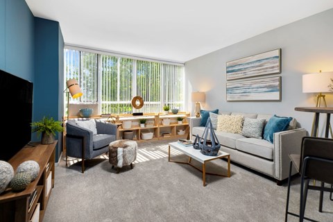 A living room with a grey sofa, a wooden coffee table, and a painting on the wall.