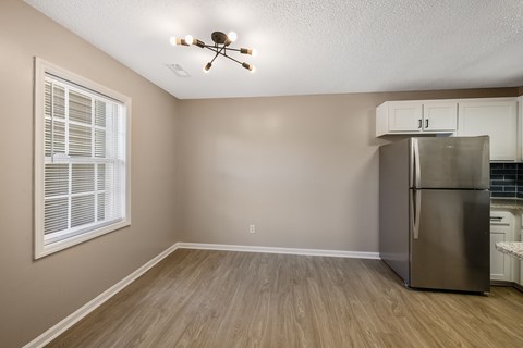 A kitchen with a refrigerator and a ceiling fan.