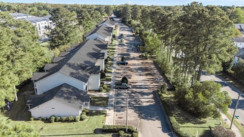A long row of houses with trees on the side. at Spring Lake Apartments in Greenville, NC