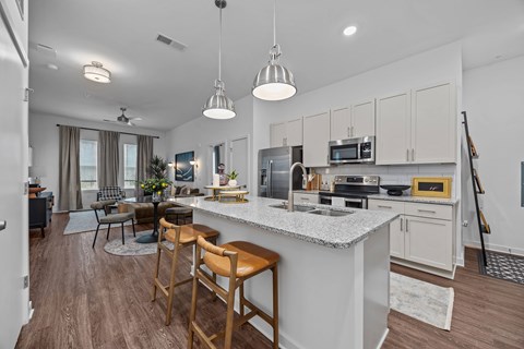 A kitchen with a white countertop and wooden bar stools.at Address East End, Raleigh, 27610
