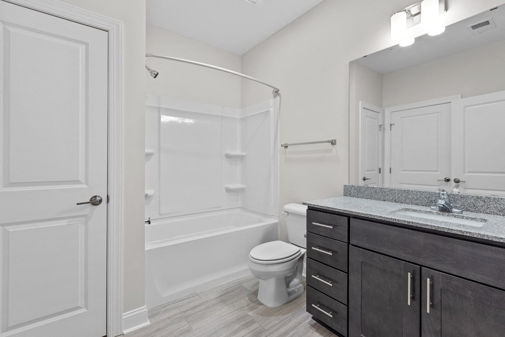 a bathroom with a toilet and a shower and a sink