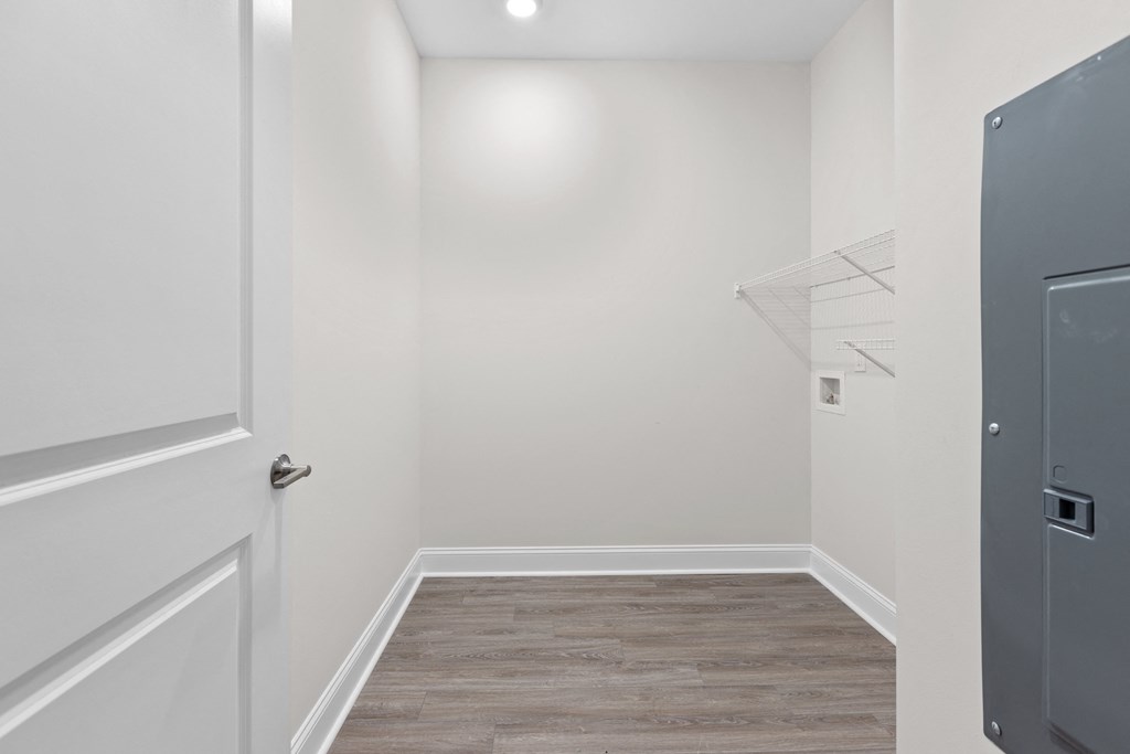 an empty room with white walls and a door to a closet