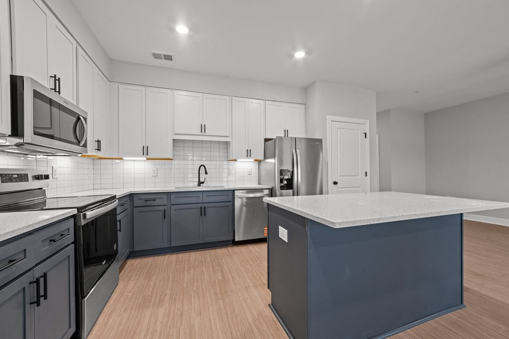 A modern kitchen with a large island and stainless steel appliances.at Regency Townes, Winterville, NC 28590
