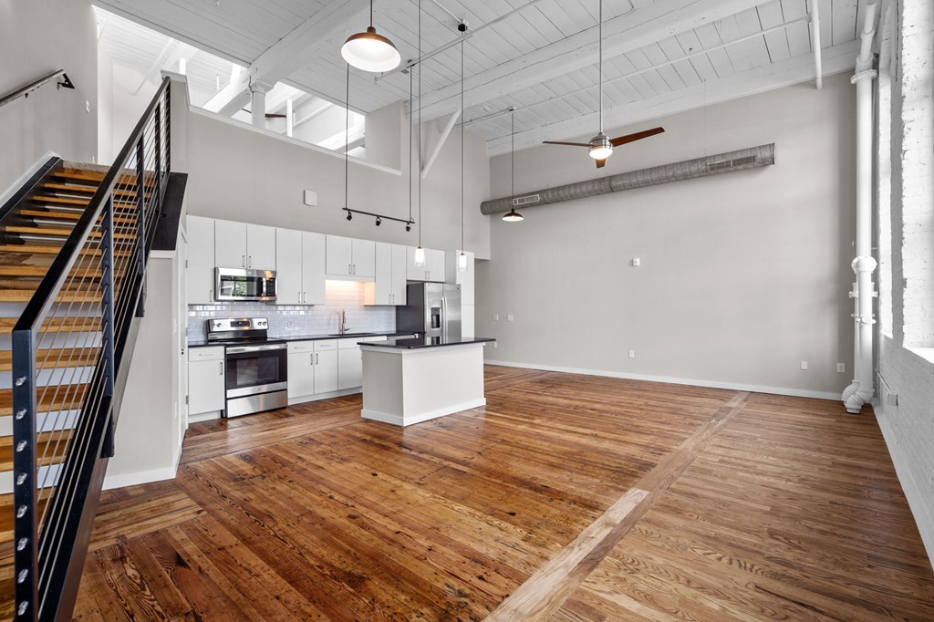 an open living room with a kitchen and a staircase