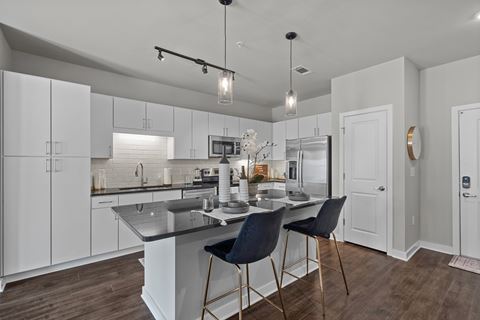 a kitchen with white cabinets and a island with two stools