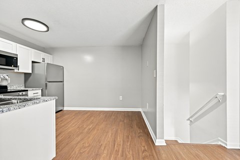 A kitchen with a refrigerator, microwave, and sink.