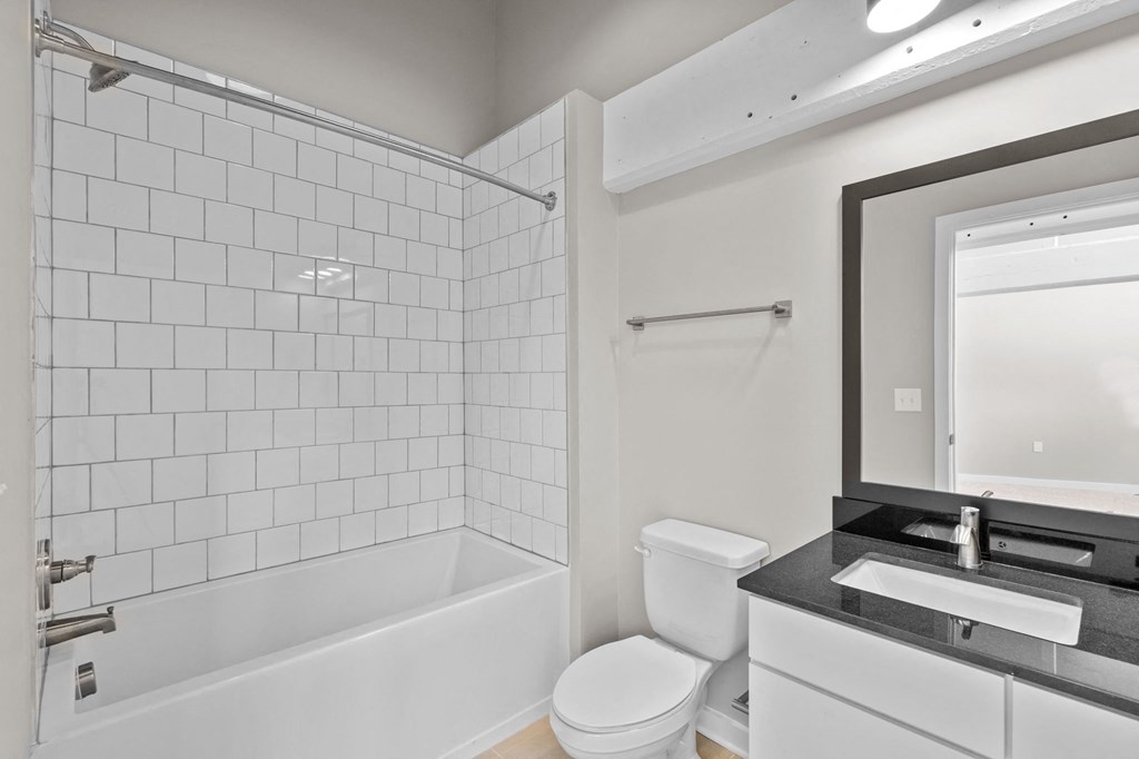 a white bathroom with a white toilet and a tub and a sink