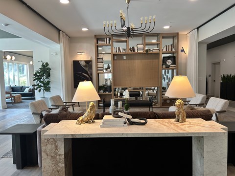 A modern living room with a marble table and a chandelier.