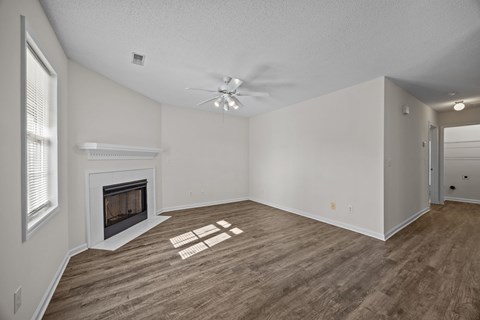 A room with a fireplace and a fan on the ceiling.