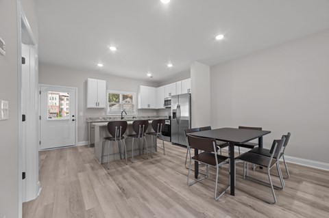 A kitchen with a table and chairs in the middle of the room.
