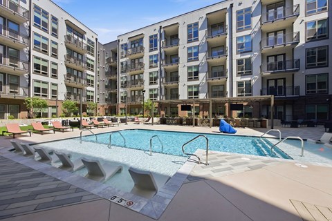 Resort style pool with sundeck loungers at Adler Montford Park + Drexel Townes Apartments, North Carolina