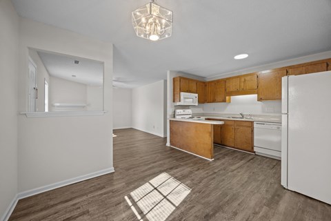 A kitchen with white appliances and wooden cabinets.