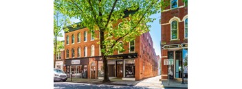 a building on the corner of a street with a tree at Taft Lofts, Frederick