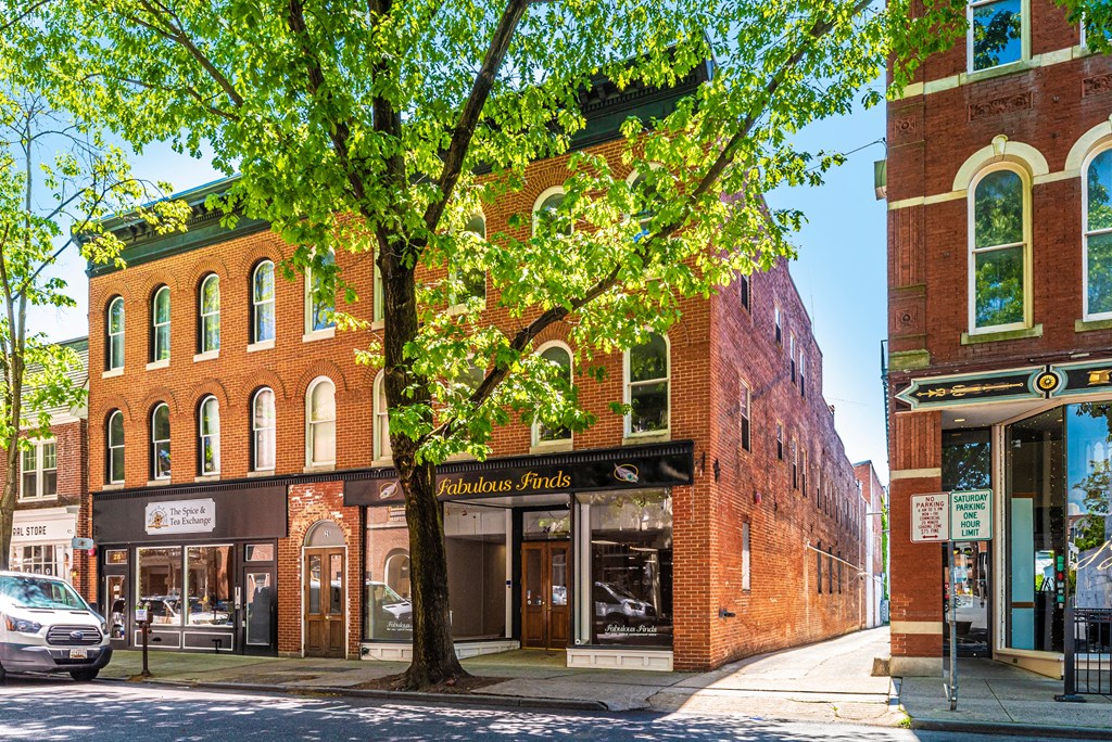 a building on the corner of a street with a tree
