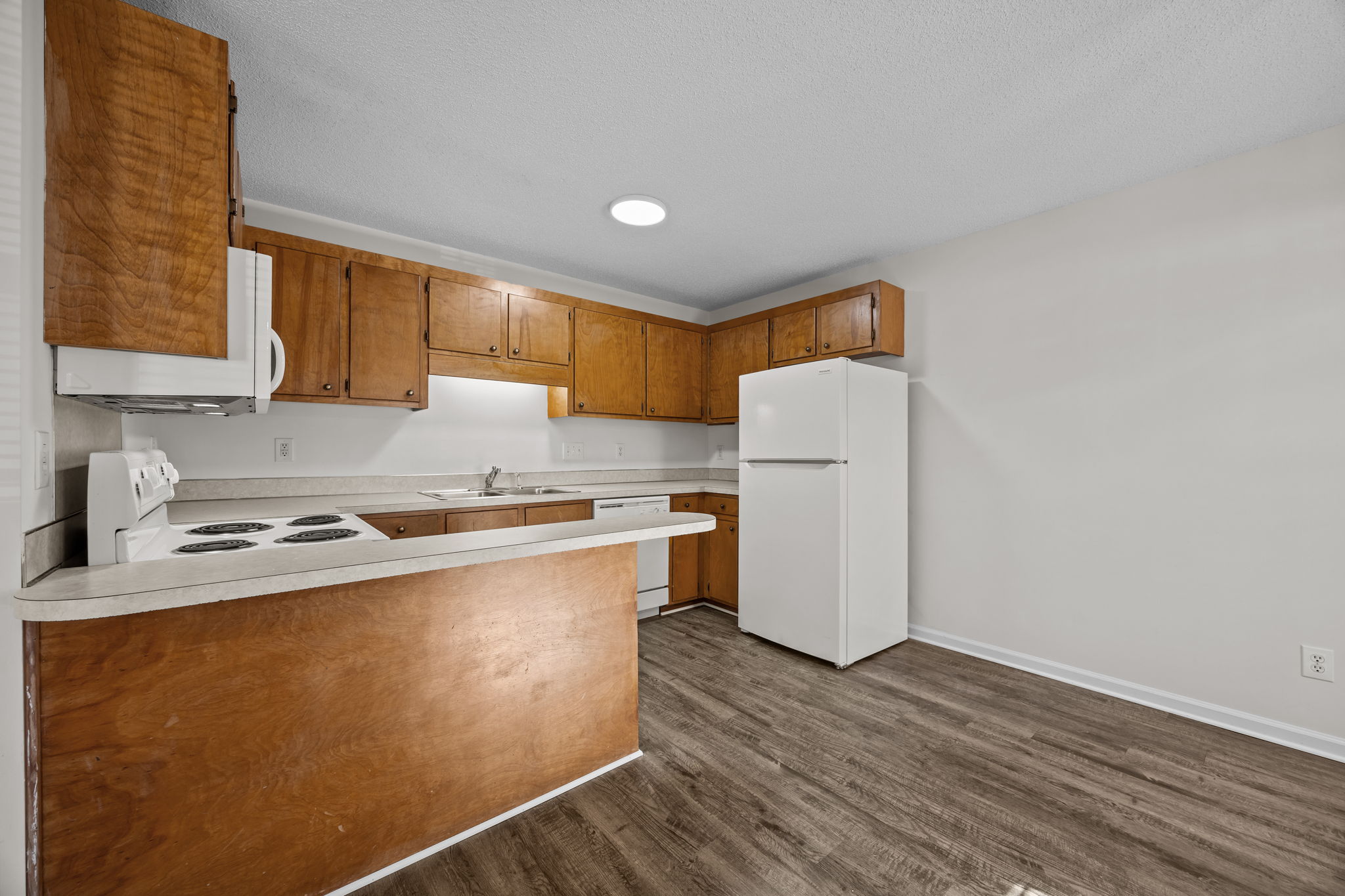 A kitchen with wooden cabinets and a white refrigerator.