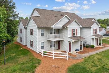 a large white house with a porch and a deck at Granville Oaks Apartment Homes, North Carolina, 27522
