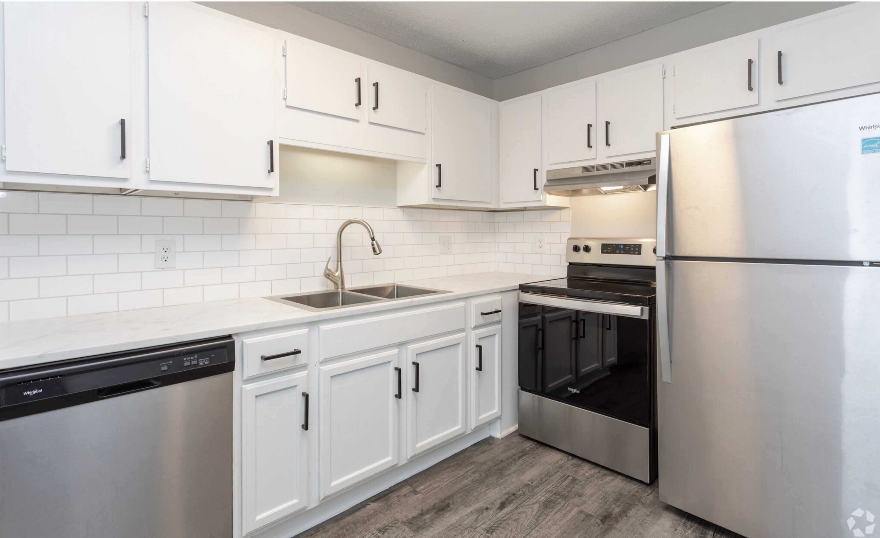 A kitchen with white cabinets and stainless steel appliances.