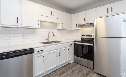 A kitchen with white cabinets and stainless steel appliances.