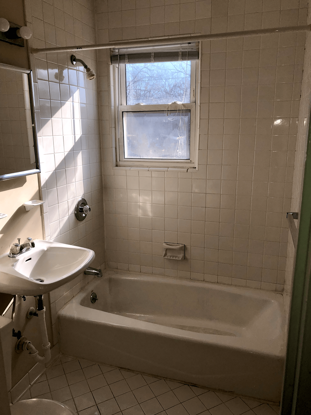 a bathroom with a tub and a sink and a window