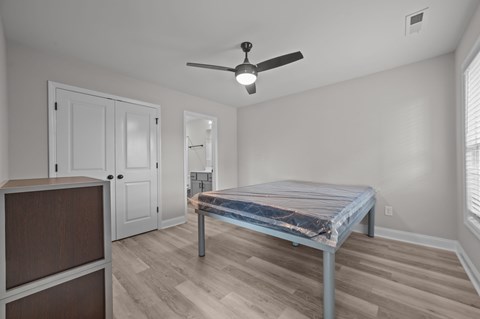 A bedroom with a bed, dresser, and mirror.