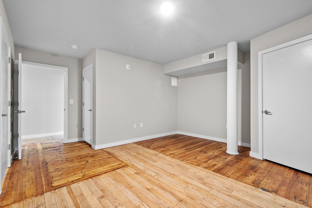an empty living room with wood flooring and white walls