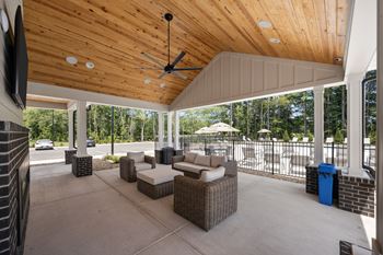 A patio with a ceiling fan and a couch at Regency Townes in Greenville, NC