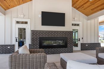 A modern living room with a fireplace and a flat screen TV mounted above it at Regency Townes in Greenville, NC