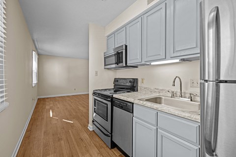 an empty kitchen with white cabinets and stainless steel appliances at Raleigh Rentals, North Carolina