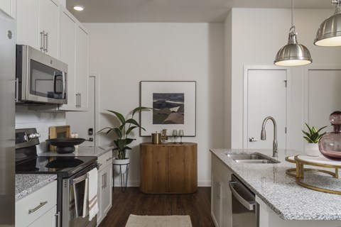 A kitchen with a white countertop and a wooden island.
