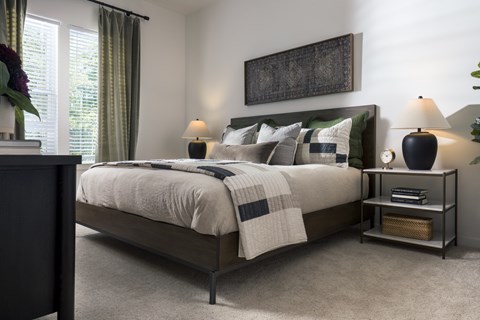 A bedroom with a large bed and a painting on the wall.