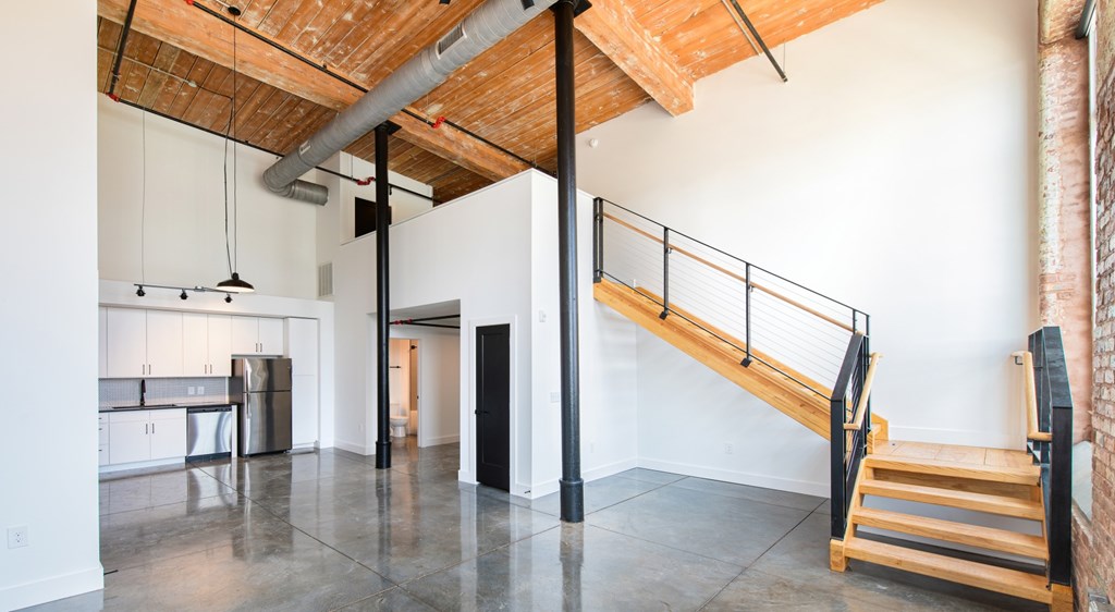 A room with a wooden ceiling and a staircase.
