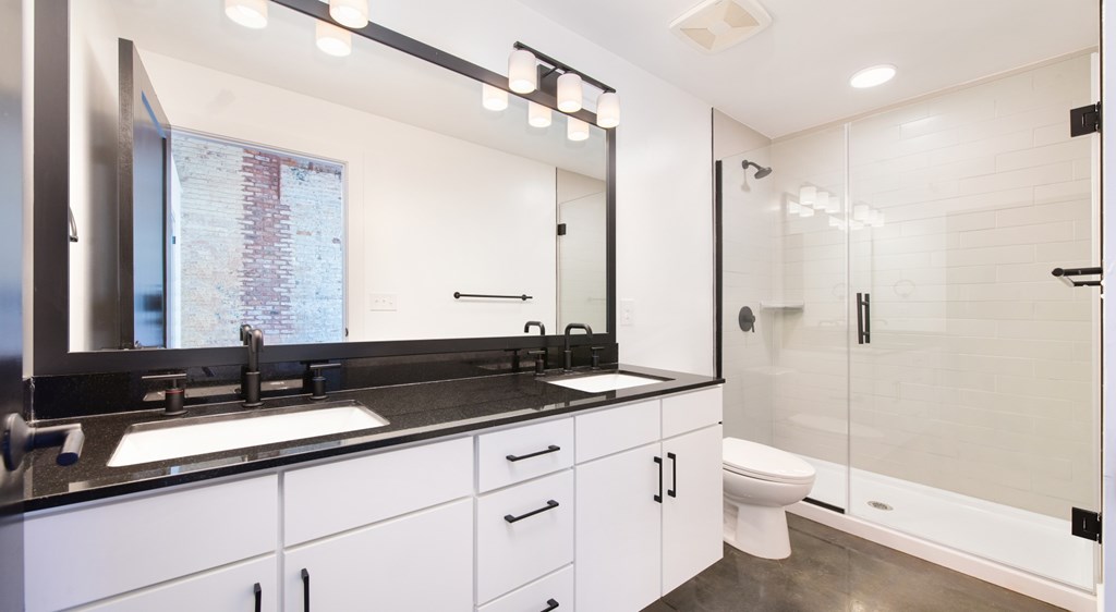 A modern bathroom with a large mirror and a sink.