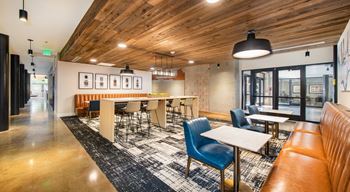 A modern dining area with wooden ceiling and a mix of blue and brown chairs at Judson Mill Lofts, South Carolina