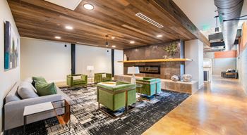 A modern living room with a wooden ceiling and a green ottoman at Judson Mill Lofts, Greenville