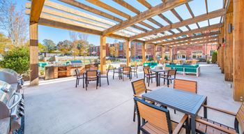 A patio with tables and chairs under a wooden pergola at Judson Mill Lofts, South Carolina