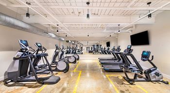 A gym with treadmills and exercise bikes at Judson Mill Lofts, Greenville, 29611
