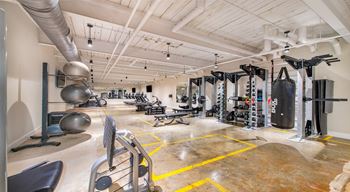 A gym with a variety of equipment including weights and machines at Judson Mill Lofts, Greenville, SC