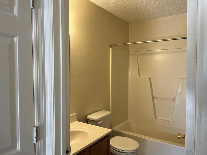 a bathroom with a toilet and a sink and a shower