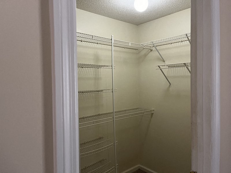 a walk in closet with empty shelves