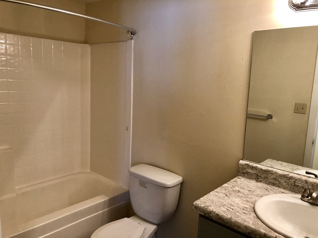 a bathroom with a toilet and a sink and a shower