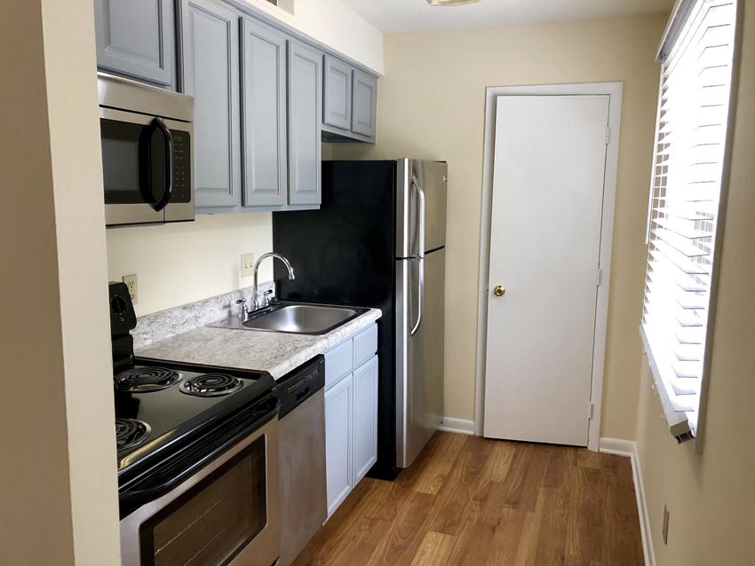 a kitchen with stainless steel appliances and a black refrigerator